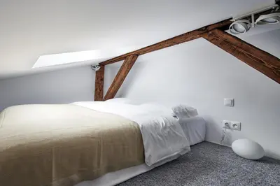 a bedroom with white walls and a large bed at OLD NEW - Prime Location on Main Square in Kraków