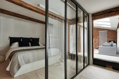 a bedroom with a bed and glass walls at OLD NEW - Prime Location on Main Square in Kraków