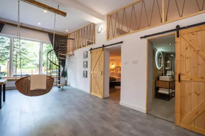 a large room with wooden doors and a bedroom at Staymoovers - Secret Loft w pobliżu Krakowa in Paszkówka