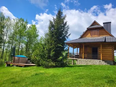 a log cabin with a bench and a hot tub at Gorczańska Ostoja in Klikuszowa