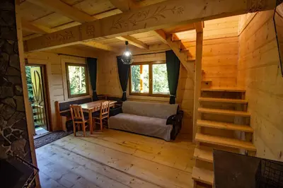 a living room of a log cabin with a couch and a table at Gorczańska Ostoja in Klikuszowa