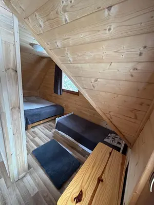 a room with two beds and a bench in a tiny house at Gorczańska Ostoja in Klikuszowa