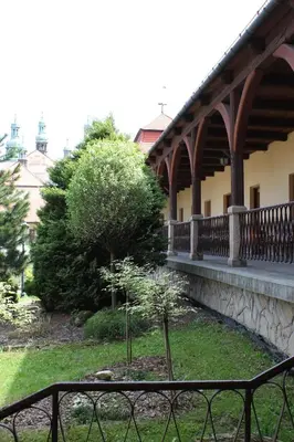 a fence in front of a building with a garden at Dom Pielgrzyma in Kalwaria Zebrzydowska