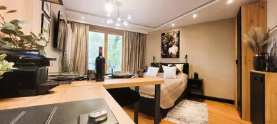 a bedroom with a bed and a desk and a piano at Apartamenty Kossak Residence in Kraków