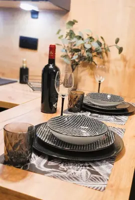 a table with two plates and a bottle of wine at Apartamenty Kossak Residence in Kraków