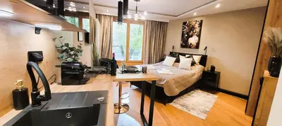 a room with a bed and a desk with a sink at Apartamenty Kossak Residence in Kraków