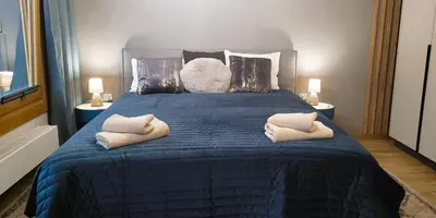a bedroom with a blue bed with two pillows on it at Apartamenty Kossak Residence in Kraków