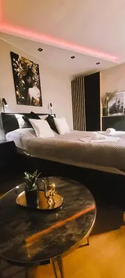 a hotel room with a bed and a coffee table at Apartamenty Kossak Residence in Kraków