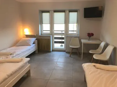 a room with two beds and a table and a window at Noclegi Bachowice - Zator Energylandia Wadowice in Bachowice