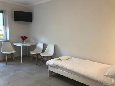 a bedroom with a bed and a table and chairs at Noclegi Bachowice - Zator Energylandia Wadowice in Bachowice