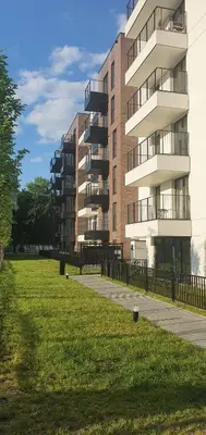 a large apartment building with a grass field in front of it at Apartament Green Diamond Rakowicka in Kraków