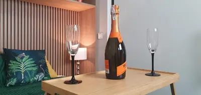 a bottle of wine on a table with two glasses at Apartament Green Diamond Rakowicka in Kraków