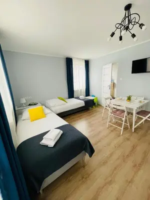 a bedroom with a bed and a living room at Gladiator Noclegi Zator lll in Zator