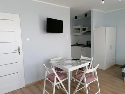 a white dining room with a table and two chairs at Gladiator Noclegi Zator lll in Zator