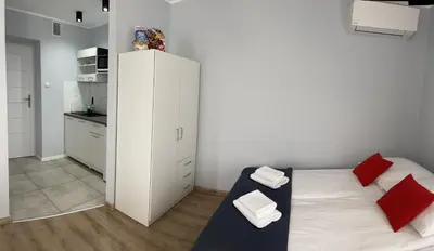 a small bedroom with a bed with red pillows at Gladiator Noclegi Zator lll in Zator
