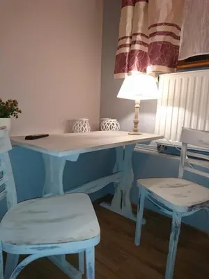 a desk with two chairs and a table with a lamp at NOCLEGI POD STODOŁĄ in Kraków