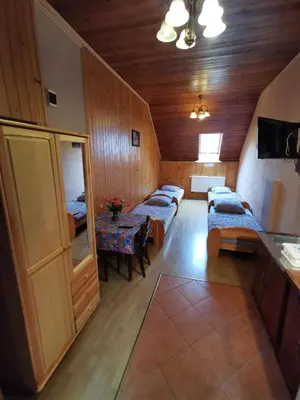 a room with three beds and a table in it at NOCLEGI POD STODOŁĄ in Kraków