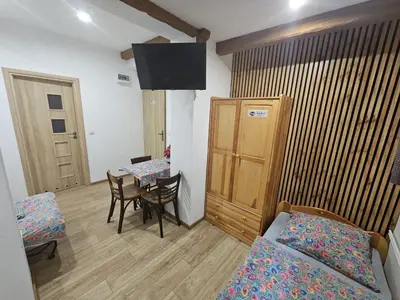 a room with a table and a bed and a table and chairs at NOCLEGI POD STODOŁĄ in Kraków