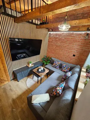 a living room with a couch and a tv at NOCLEGI POD STODOŁĄ in Kraków