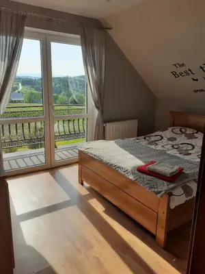 a bedroom with a bed and a large window at Dom w okolicach Czchowa in Wytrzyszczka