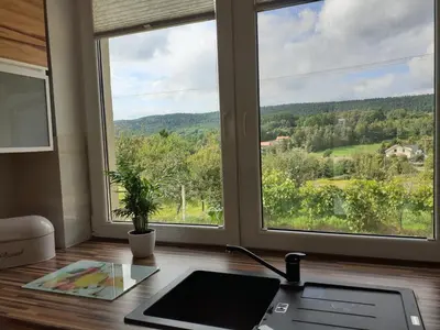 an office with a desk with a laptop and a window at Dom w okolicach Czchowa in Wytrzyszczka