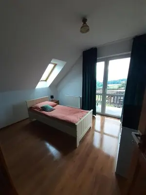 a bedroom with a bed and a large window at Dom w okolicach Czchowa in Wytrzyszczka
