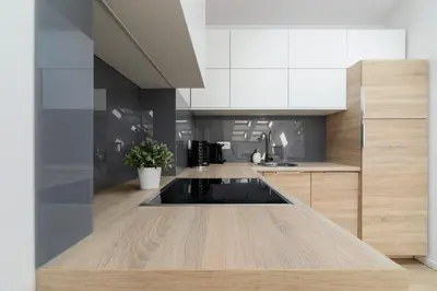 a kitchen with white cabinets and a wooden counter top at Apartments Dietla Cracow by Noclegi Renters in Kraków