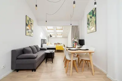 a living room with a green couch and a table at Apartments Dietla Cracow by Noclegi Renters in Kraków