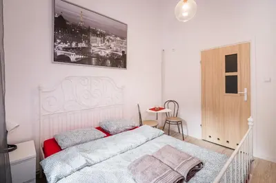a bedroom with a white bed with two pillows at Laykonik in Kraków