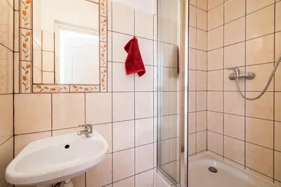 a bathroom with a shower and a sink and a mirror at KRAKOWIAK in Kraków