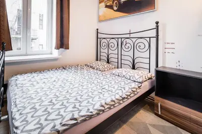 a bed sitting in a room with a window at KRAKOWIAK in Kraków