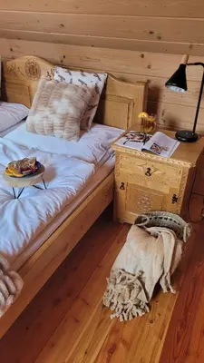 a dog laying on the floor next to a bed at Sękata Chata Zawoja in Zawoja