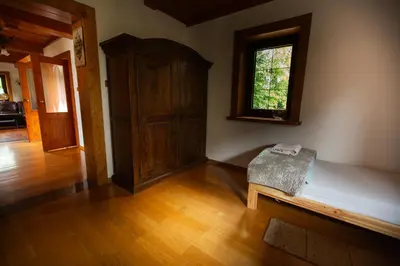 a room with a bed and a window and a wooden floor at Zbójnicka Chata in Wieliczka