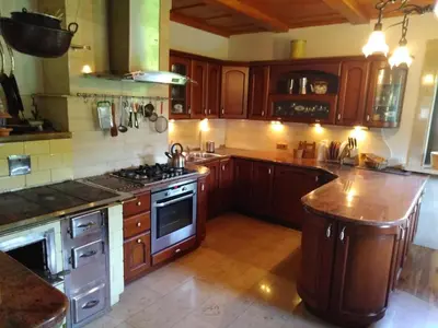 a kitchen with wooden cabinets and a stove top oven at Zbójnicka Chata in Wieliczka