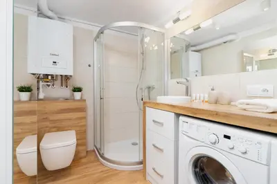 a bathroom with a shower and a washing machine at Duplex Apartment Brandy Cracow by Noclegi Renters in Kraków