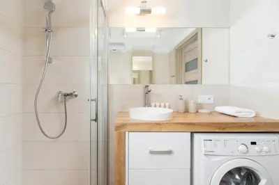 a bathroom with a shower and a sink and a washing machine at Duplex Apartment Brandy Cracow by Noclegi Renters in Kraków
