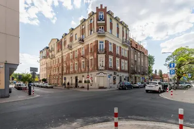 a large building on a street with cars parked on the street at Duplex Apartment Brandy Cracow by Noclegi Renters in Kraków