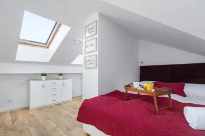a attic bedroom with a bed and a table at Duplex Apartment Brandy Cracow by Noclegi Renters in Kraków