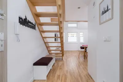 a living room with a staircase and a table at Duplex Apartment Brandy Cracow by Noclegi Renters in Kraków