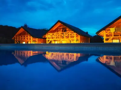 a log cabin by the water at night at Chatki U Hanusi in Czchów
