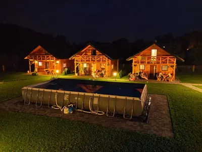 a house with a pool in the yard at night at Chatki U Hanusi in Czchów