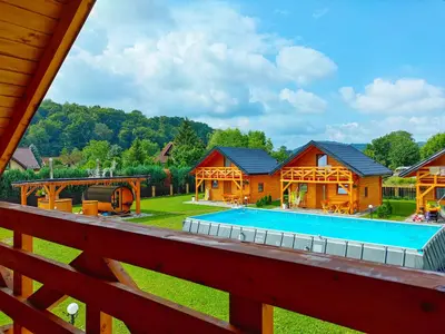 a log home with a pool and a house at Chatki U Hanusi in Czchów