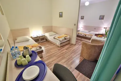 a view of a room with two beds and a table at Parkowy Dworek in Rabka