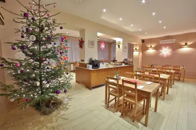 a christmas tree in a restaurant with tables and chairs at Parkowy Dworek in Rabka
