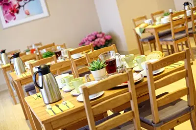 a long wooden table with chairs and a table with at Parkowy Dworek in Rabka