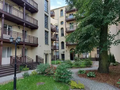 an apartment building with a tree in front of it at JUWEL Uroczy Apartament 2A Stare Miasto Kraków in Kraków