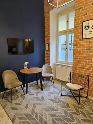 a room with two chairs and a table and a tv at JUWEL Uroczy Apartament 2A Stare Miasto Kraków in Kraków