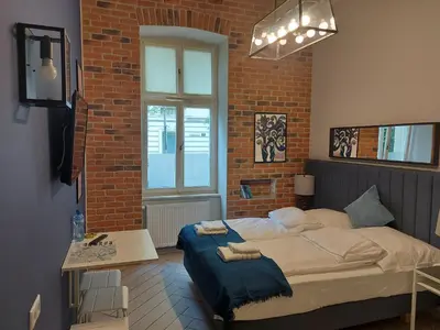 a bedroom with a bed and a brick wall at JUWEL Uroczy Apartament 2B Stare Miasto Kraków in Kraków