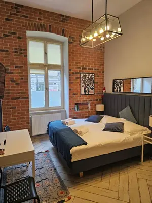 a bedroom with a bed and a brick wall at JUWEL Uroczy Apartament 2B Stare Miasto Kraków in Kraków