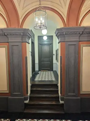 a hallway with a door and stairs in a building at JUWEL Uroczy Apartament 2B Stare Miasto Kraków in Kraków